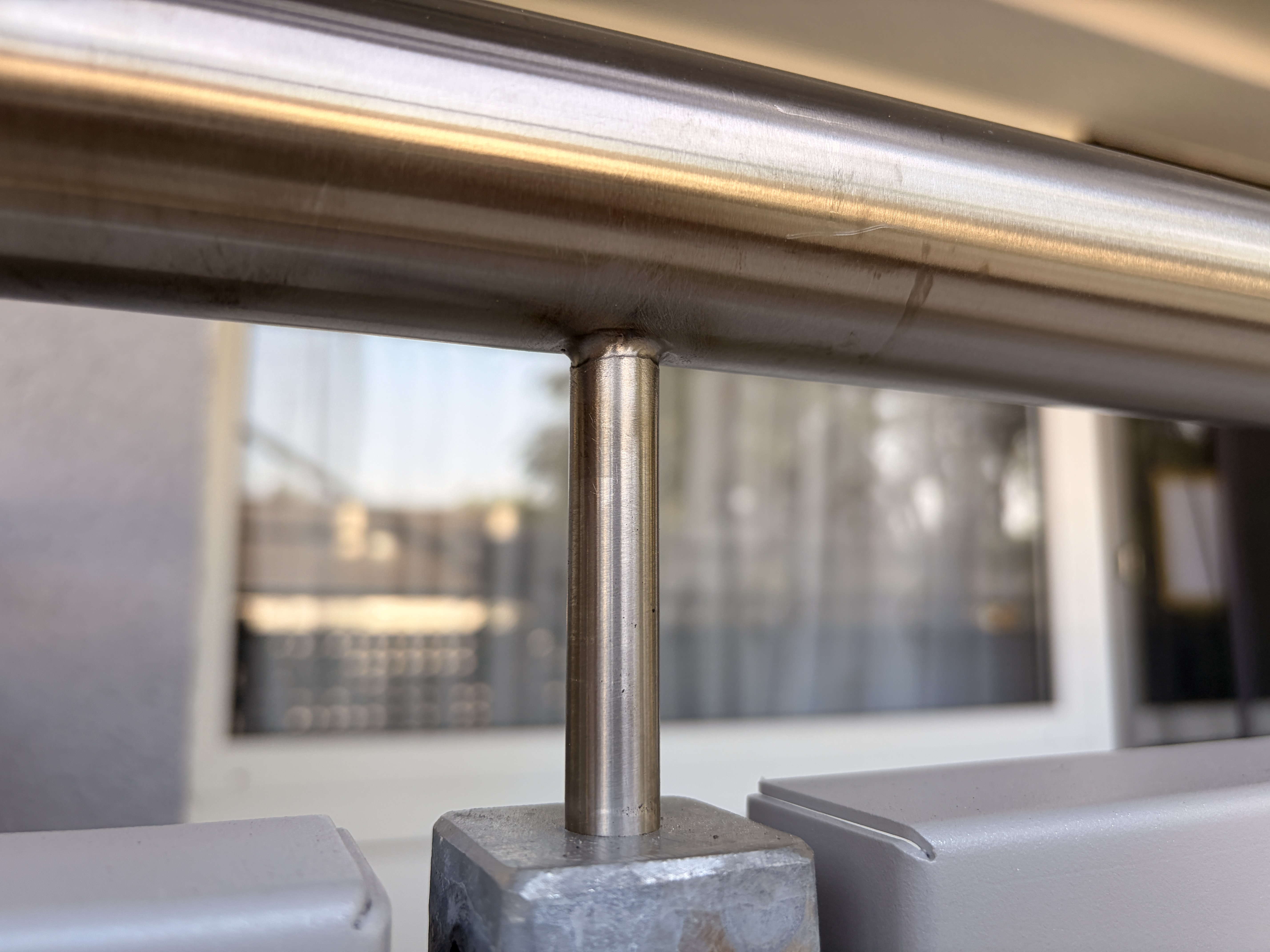 Detail des neuen Edelstahlhandlaufs mit senkrechtem Geländerpfosten